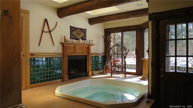 87 Red Coat Rd, Westport, CT 06880 - bathroom with healthy amount of natural light, beamed ceiling, a jetted tub, and a fireplace