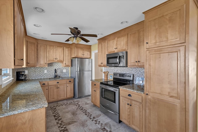 kitchen with ceiling fan, sink, stainless steel appliances, light tile patterned floors, and light stone counters