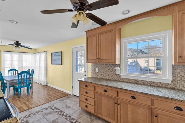 kitchen with light stone countertops, plenty of natural light, decorative backsplash, and light tile patterned floors