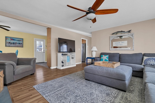 living room featuring a textured ceiling, dark wood-type flooring, and ceiling fan