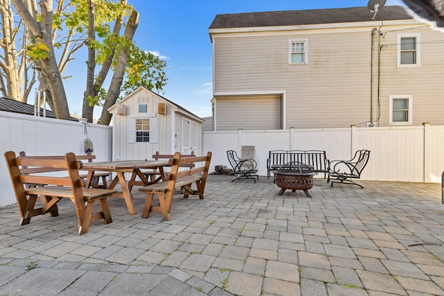 view of patio with an outbuilding and a fire pit