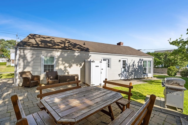 140 Salt Island Rd, Westbrook, CT 06498 - rear view of house with a chimney, a patio area, a yard, outdoor dining space, and a shingled roof