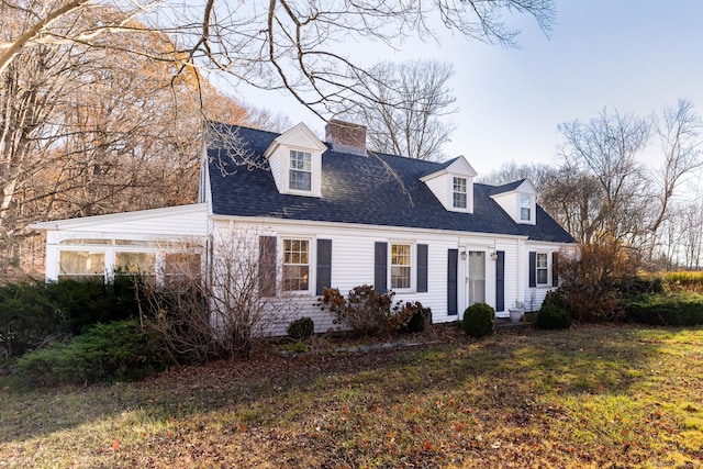 cape cod house featuring a front yard