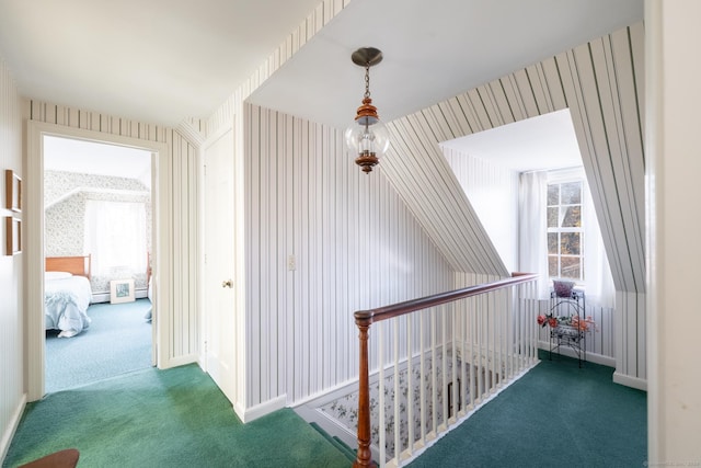 hallway with dark colored carpet and a healthy amount of sunlight