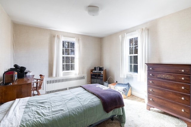 bedroom featuring carpet, radiator, and multiple windows