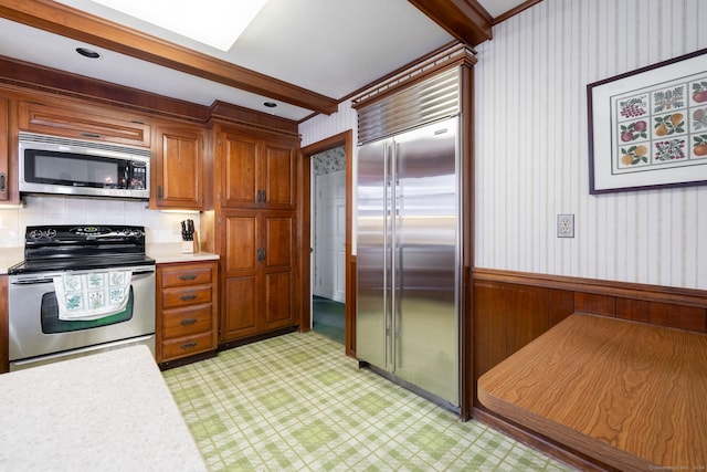 kitchen with appliances with stainless steel finishes and beam ceiling