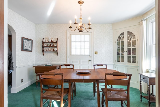 carpeted dining room featuring an inviting chandelier