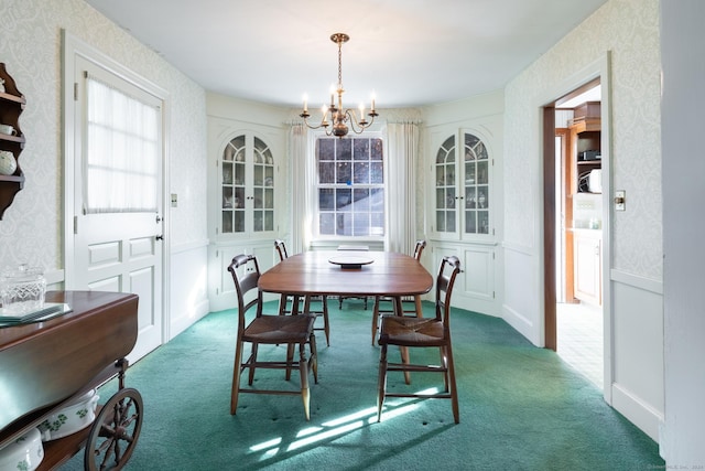 dining area featuring dark carpet and a notable chandelier