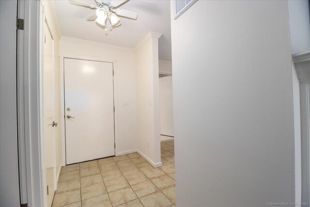 interior space featuring ceiling fan, ornamental molding, and light tile patterned floors