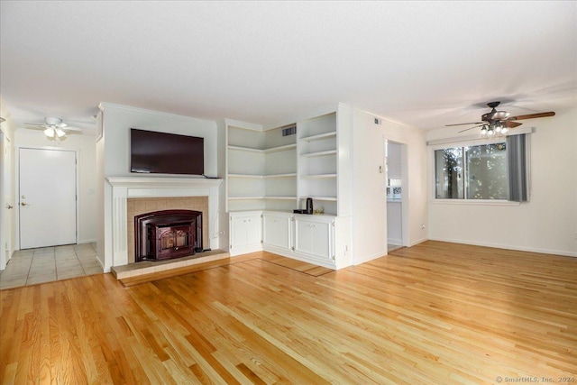 unfurnished living room featuring ceiling fan, a fireplace, and light hardwood / wood-style flooring