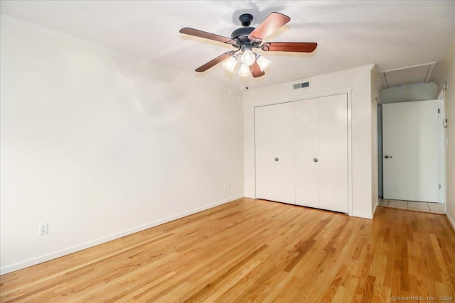 unfurnished bedroom featuring a closet, ceiling fan, crown molding, and light hardwood / wood-style flooring