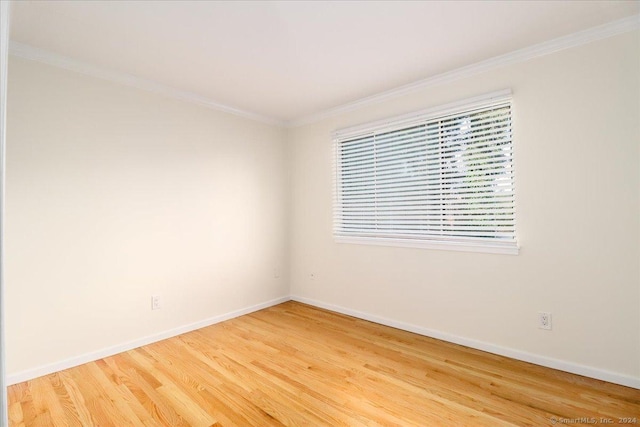 empty room featuring hardwood / wood-style flooring and crown molding