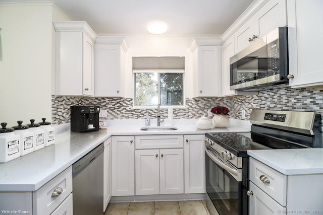 kitchen featuring stainless steel appliances, white cabinetry, and sink