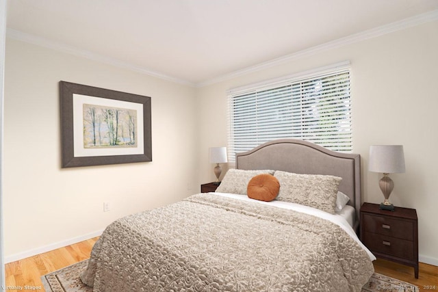 bedroom with ornamental molding and light wood-type flooring