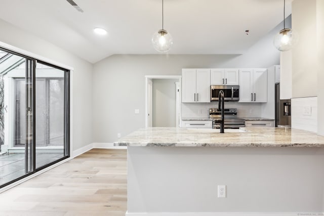 kitchen featuring white cabinets, decorative light fixtures, kitchen peninsula, and appliances with stainless steel finishes