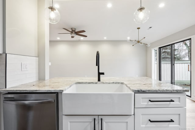 kitchen featuring dishwasher, hanging light fixtures, ceiling fan with notable chandelier, and sink