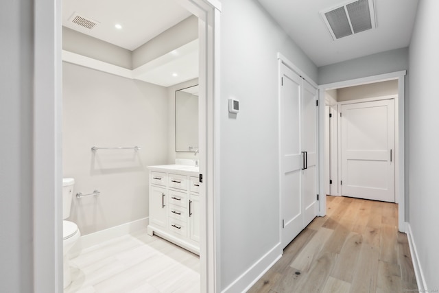 bathroom featuring vanity, toilet, and wood-type flooring