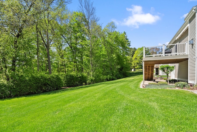 view of green lawn featuring a wooden deck
