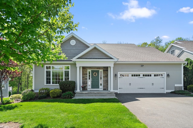 view of front of property featuring driveway, an attached garage, and a front lawn