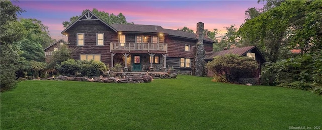 back house at dusk featuring a yard