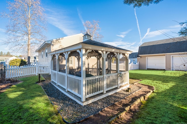 rear view of property featuring a lawn, a garage, and an outdoor structure