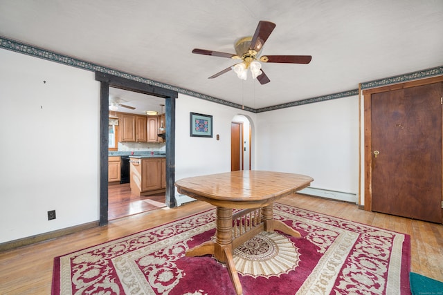 dining room featuring ceiling fan, a baseboard heating unit, and light wood-type flooring