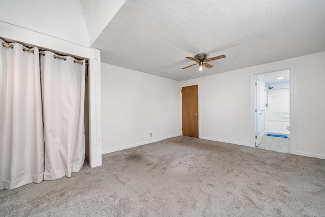 spare room with light carpet, ceiling fan, and a textured ceiling