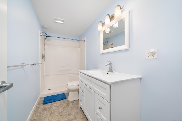 bathroom featuring a shower, vanity, and toilet