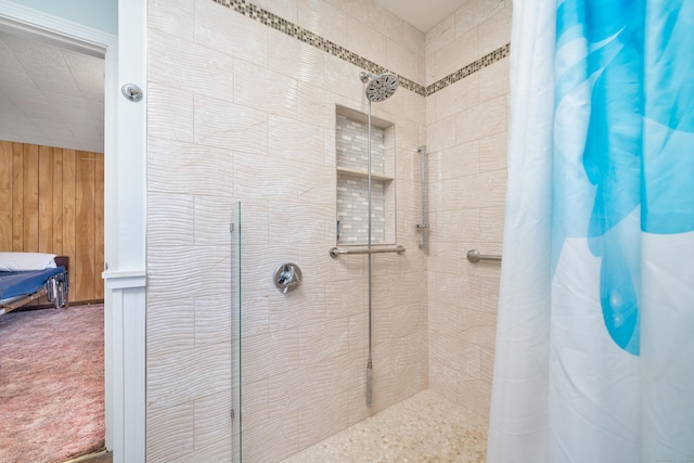 bathroom featuring a shower with shower curtain and wooden walls