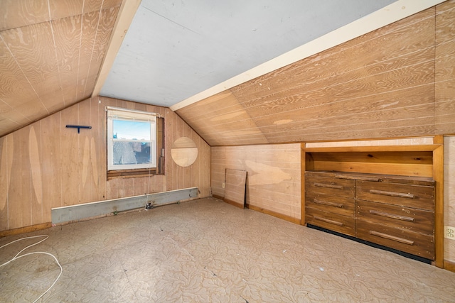 bonus room with wooden walls and lofted ceiling