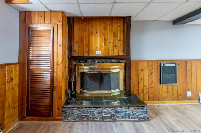 unfurnished living room with light hardwood / wood-style flooring and wooden walls