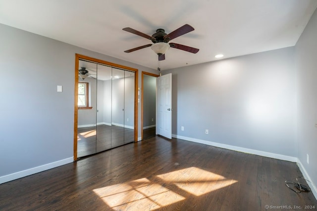 unfurnished bedroom featuring ceiling fan, dark wood-type flooring, and a closet