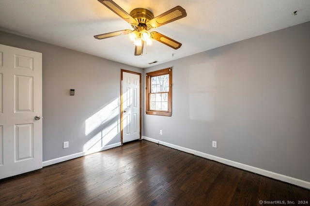 empty room with ceiling fan and dark hardwood / wood-style flooring