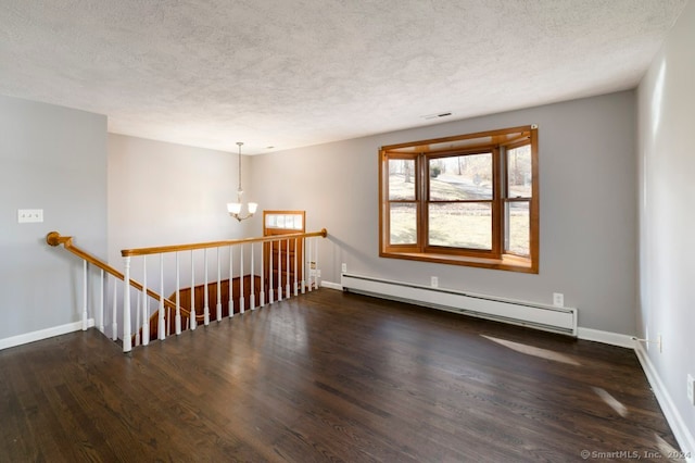 unfurnished room featuring a textured ceiling, a chandelier, dark wood-type flooring, and a baseboard heating unit