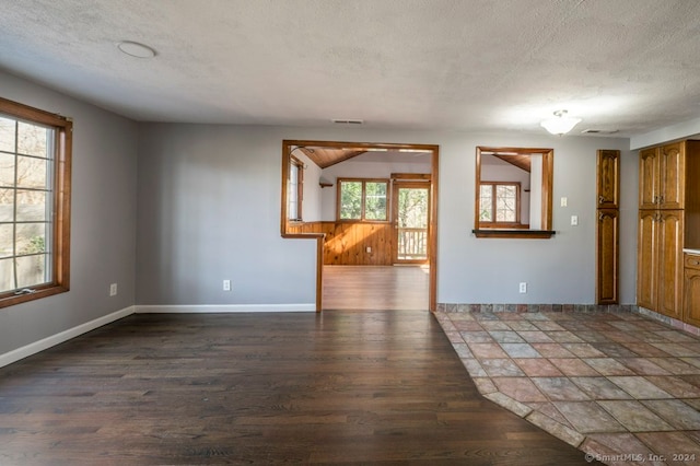 unfurnished room with dark hardwood / wood-style flooring, a textured ceiling, and wood walls