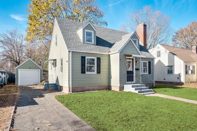 cape cod home with an outbuilding, a garage, and a front lawn