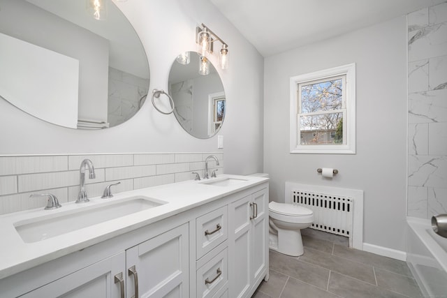 bathroom with toilet, radiator heating unit, vanity, and tile patterned floors