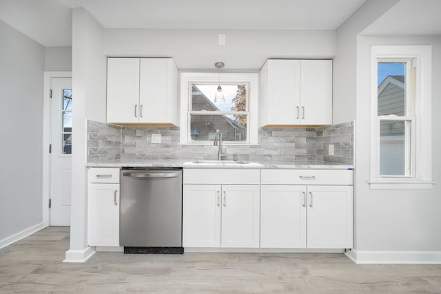 kitchen featuring white cabinetry, stainless steel dishwasher, hanging light fixtures, and sink