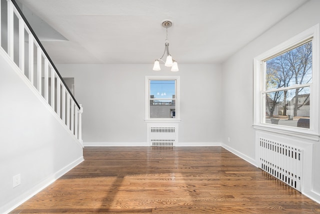 unfurnished dining area with dark hardwood / wood-style flooring, a wealth of natural light, and radiator heating unit