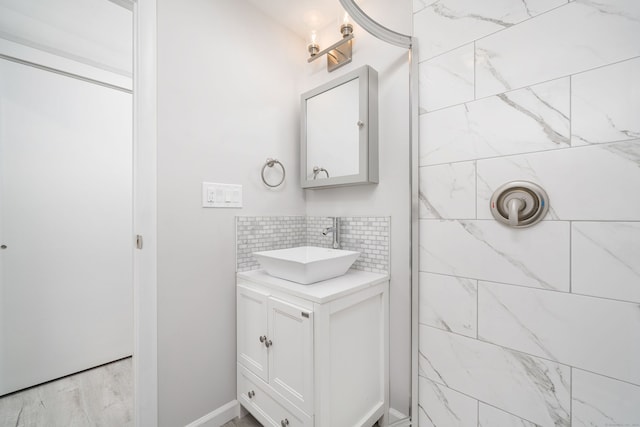 bathroom featuring tasteful backsplash, vanity, and tiled shower