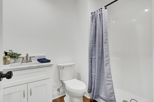 bathroom featuring hardwood / wood-style flooring, vanity, curtained shower, and toilet