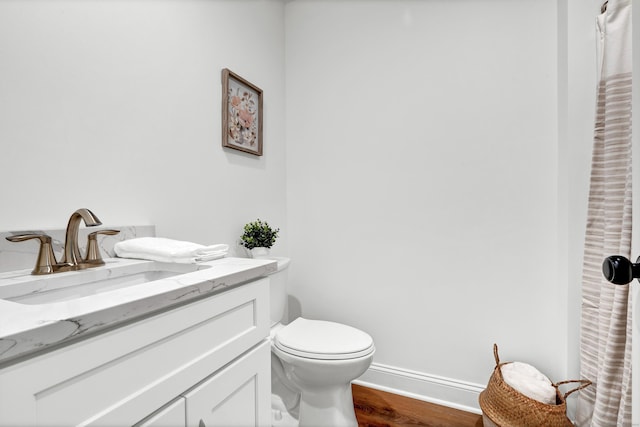 bathroom with vanity, hardwood / wood-style flooring, and toilet