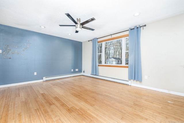 spare room featuring a textured ceiling, ceiling fan, a baseboard heating unit, and hardwood / wood-style flooring