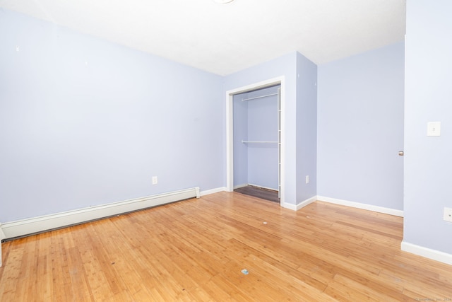 unfurnished room featuring light hardwood / wood-style floors and baseboard heating