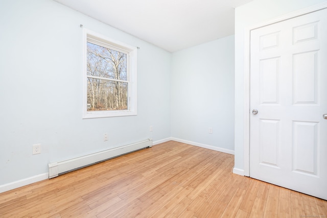 unfurnished room with light hardwood / wood-style flooring and a baseboard heating unit