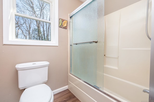 bathroom featuring shower / bath combination with glass door, wood-type flooring, and toilet