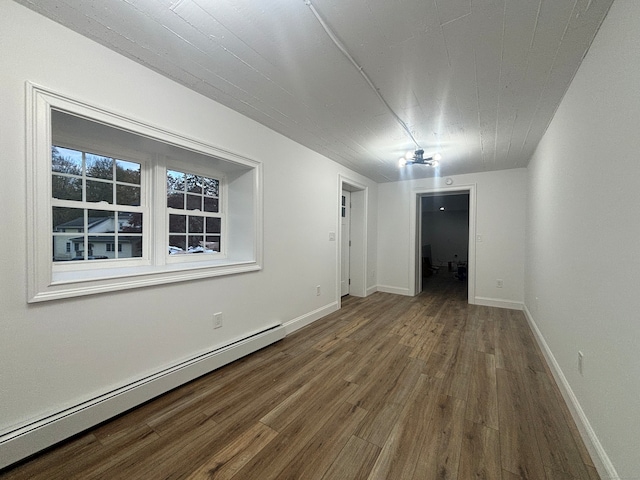 spare room featuring wood-type flooring and a baseboard heating unit