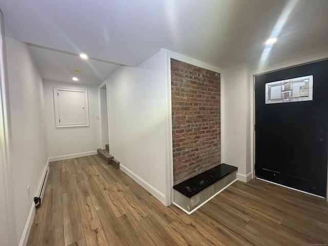 foyer entrance with wood-type flooring and a baseboard radiator