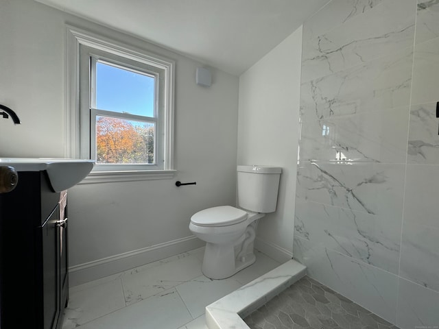 bathroom with sink, toilet, and tiled shower