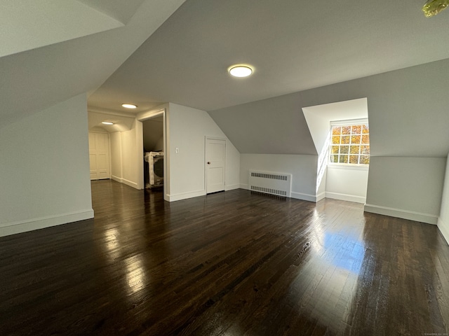 bonus room with radiator, dark wood-type flooring, and lofted ceiling